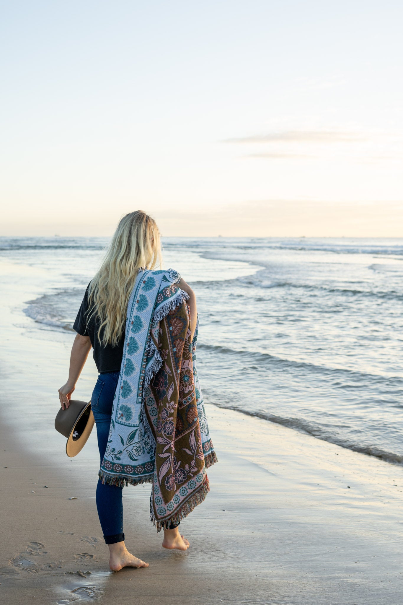 Girl on beach with green floral florence throw wrapped around her