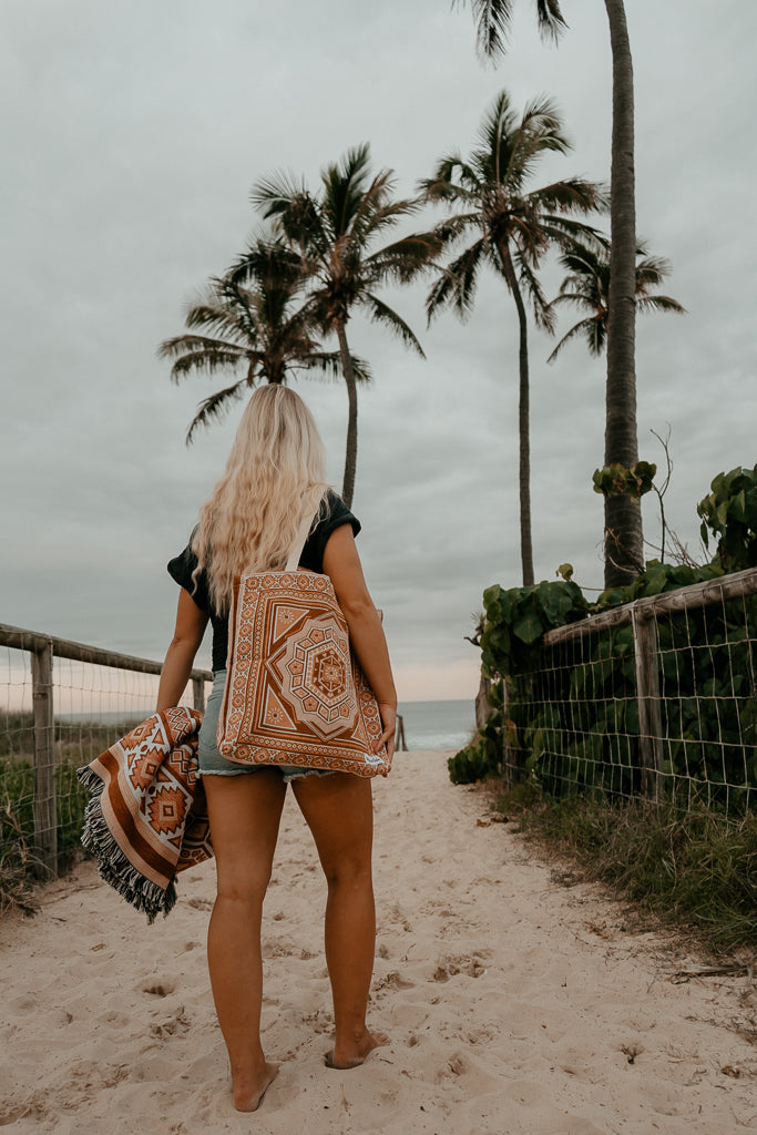 cotton bag on shoulder, palm trees in background