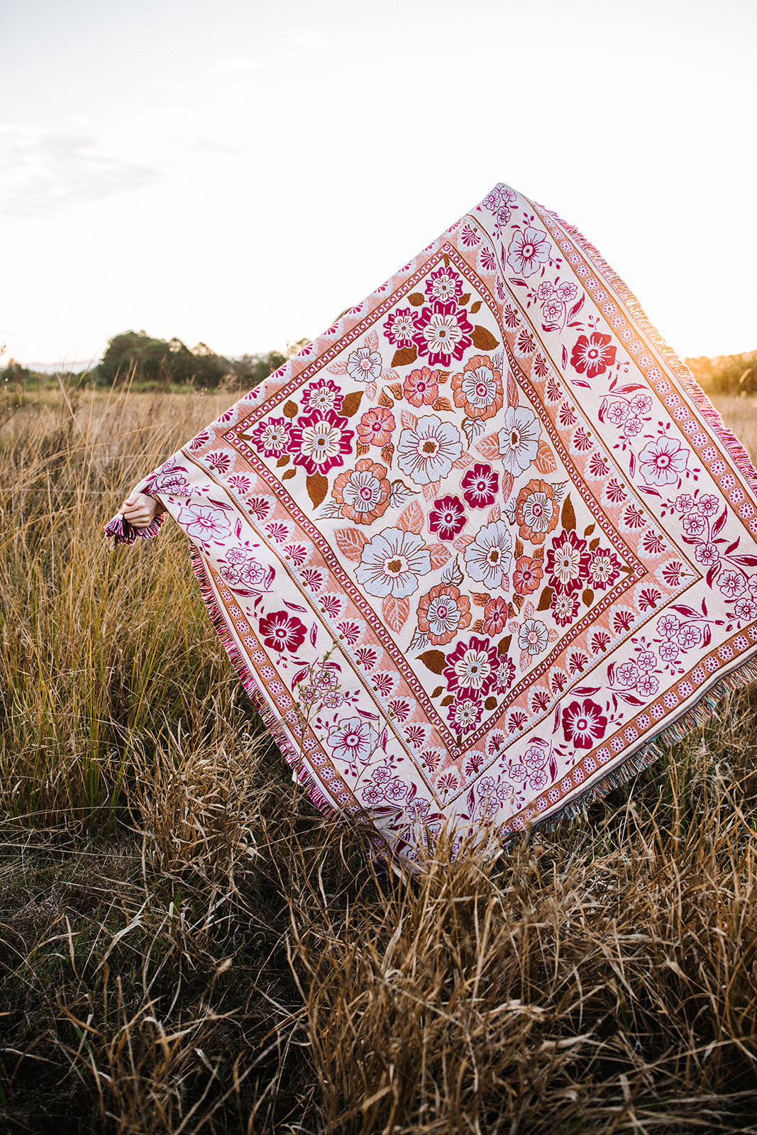 Girl in grass field with pink floral florence throw 